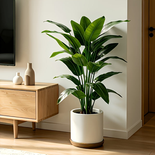 Realistische kunst bananenplant van 100 cm met grote groene tropische bladeren in witte sierpot, vooraanzicht op witte achtergrond.