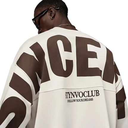 Oversized heren T-shirt in khaki, voorkant met zwarte STYNVOCLUB-letterprint, ronde hals, verlaagde schouders en grafische mouwprint op witte achtergrond.