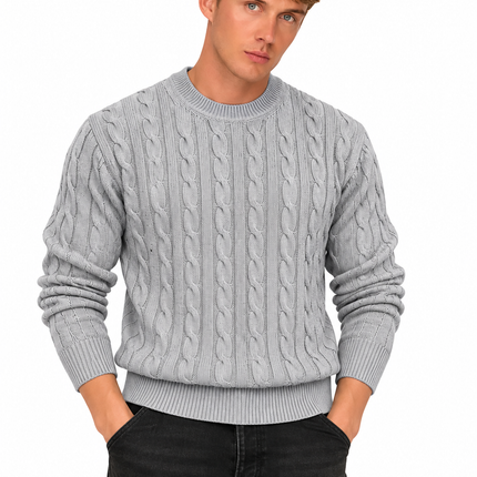 Heren kabeltrui met ronde hals, lange mouwen en klassiek kabelgebreid patroon, gedragen door een mannelijk model met een witte pantalon tegen een witte achtergrond.