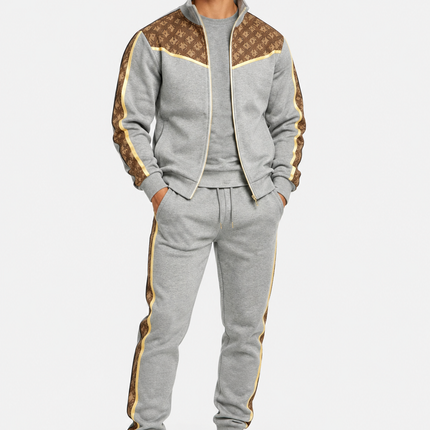 Heren trainingspak 2-delig met goudkleurige details, bruine monogrampanelen, vest met opstaande kraag en rits en bijpassende joggingbroek met zijstrepen.