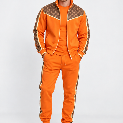Heren trainingspak 2-delig met goudkleurige details, bruine monogrampanelen, vest met opstaande kraag en rits en bijpassende joggingbroek met zijstrepen.