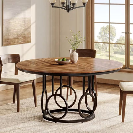 Ronde eettafel 120 cm met bruin houten tafelblad en zwart metalen onderstel met decoratieve ringen, vintage eetkamertafel voor 4 tot 6 personen op witte achtergrond.