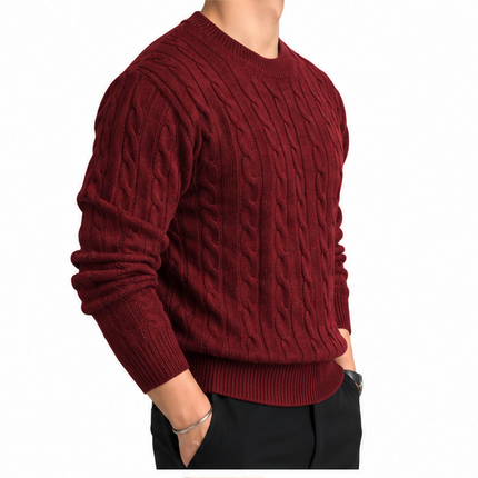 Heren kabeltrui met ronde hals, lange mouwen en klassiek kabelgebreid patroon, gedragen door een mannelijk model met een witte pantalon tegen een witte achtergrond.