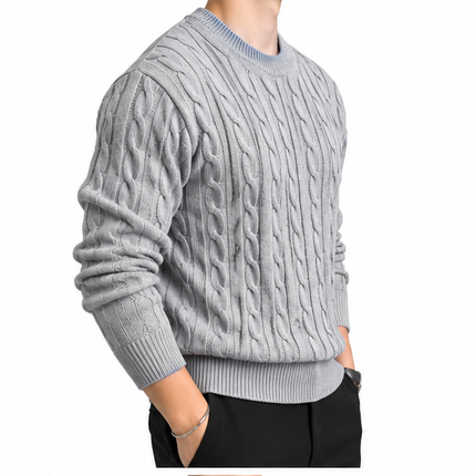 Heren kabeltrui met ronde hals, lange mouwen en klassiek kabelgebreid patroon, gedragen door een mannelijk model met een witte pantalon tegen een witte achtergrond.