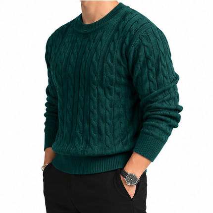 Heren kabeltrui met ronde hals, lange mouwen en klassiek kabelgebreid patroon, gedragen door een mannelijk model met een witte pantalon tegen een witte achtergrond.