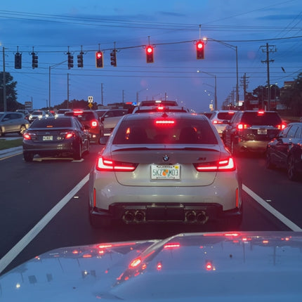 Rode LED handgebaar lamp met middelvinger symbool op de achterruit van een Dodge Durango, opvallend autogebarenlicht met afstandsbediening. 
