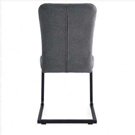 Moderne grijze eetkamerstoel met hoge rugleuning, diamantvormige stiksels, zachte stoffen bekleding en zwart metalen sledeframe, schuin van voren gefotografeerd.