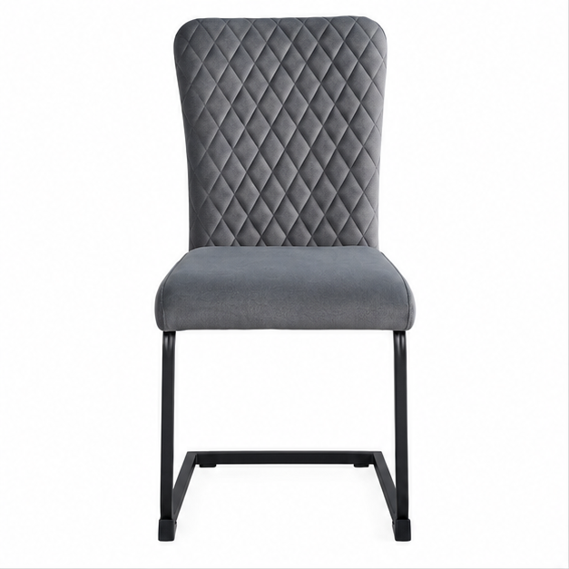Moderne grijze eetkamerstoel met hoge rugleuning, diamantvormige stiksels, zachte stoffen bekleding en zwart metalen sledeframe, schuin van voren gefotografeerd.